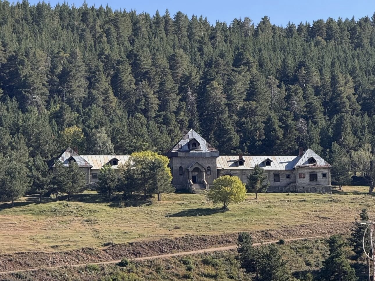 Sarıkamış Şehitliği’nden çam ormanları arasında görülen Katerina Av Köşkü’nün uzaktan görünümü.